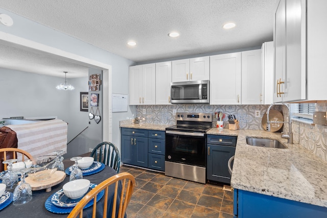 kitchen featuring stainless steel appliances, a sink, white cabinetry, and blue cabinets