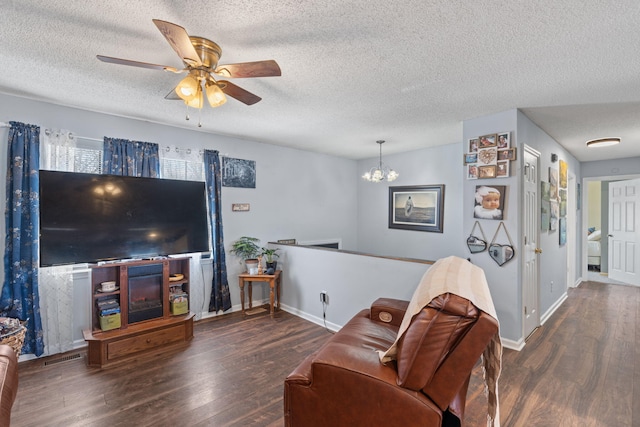 living area featuring a textured ceiling, ceiling fan with notable chandelier, and wood finished floors