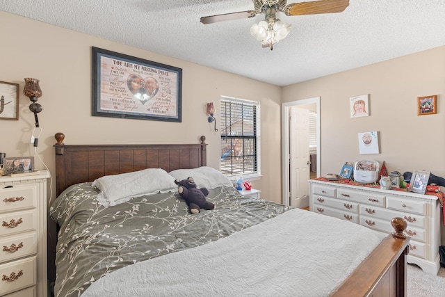 carpeted bedroom featuring ceiling fan and a textured ceiling