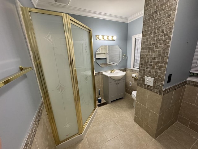 full bathroom featuring vanity, tile patterned floors, tile walls, a shower stall, and ornamental molding