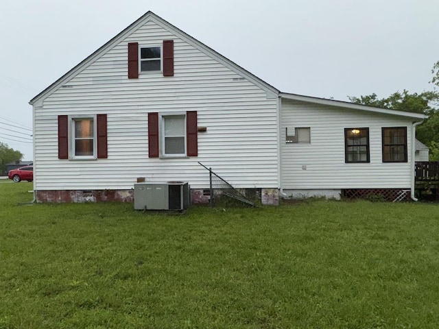 rear view of property with a lawn, crawl space, and central AC