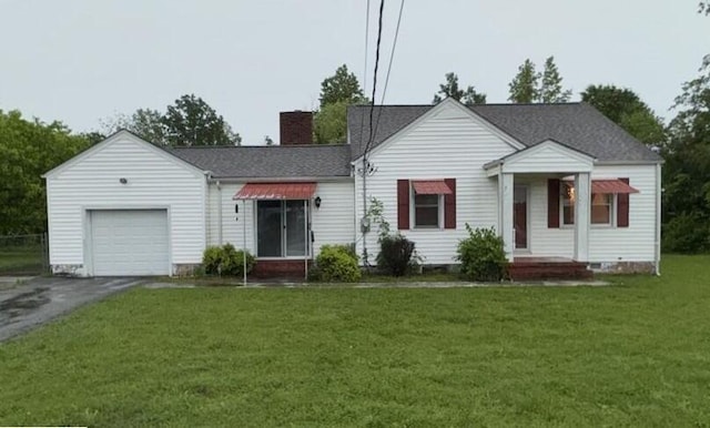 view of front of house with driveway, a chimney, roof with shingles, a garage, and a front lawn