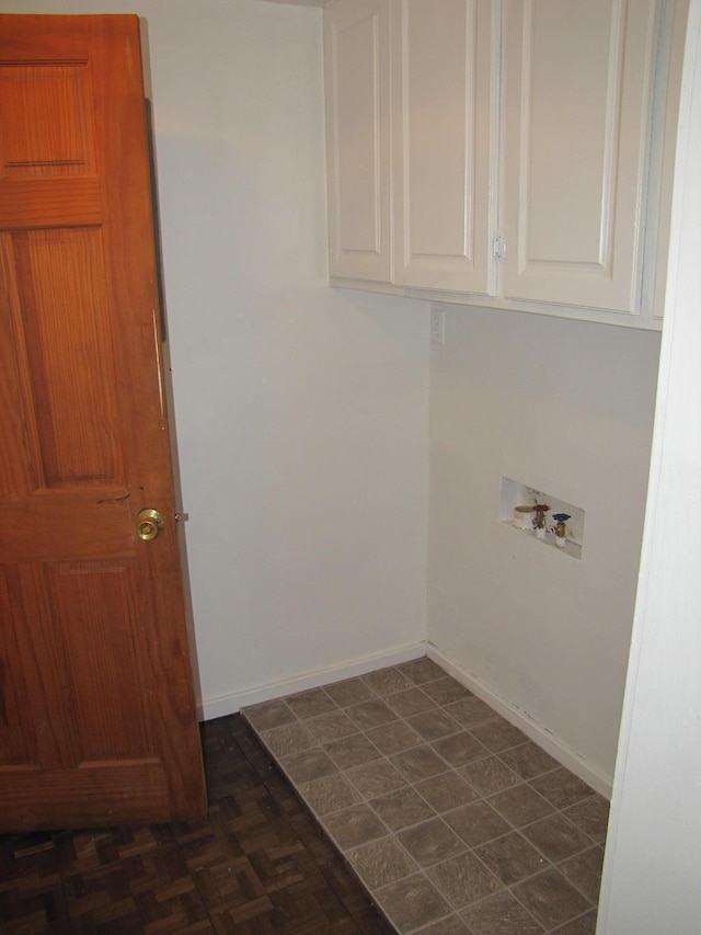 clothes washing area with hookup for a washing machine, cabinet space, and baseboards