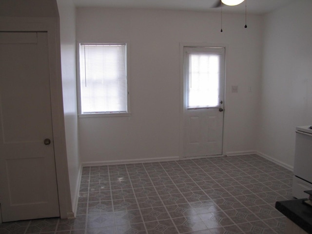 empty room featuring baseboards and tile patterned floors