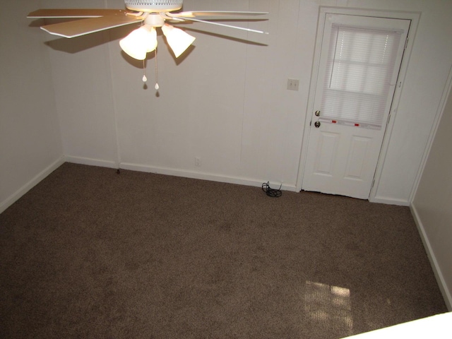 carpeted empty room featuring a ceiling fan and baseboards