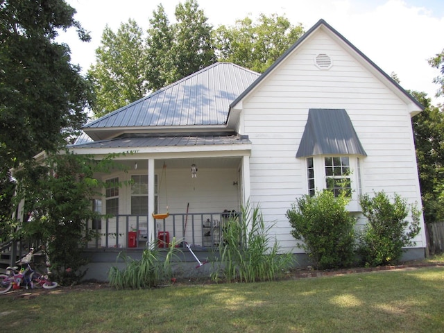 view of front of property with metal roof, a porch, and a front yard