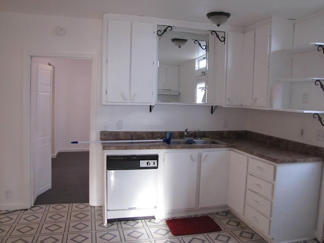 kitchen featuring dark countertops, white dishwasher, white cabinetry, open shelves, and a sink