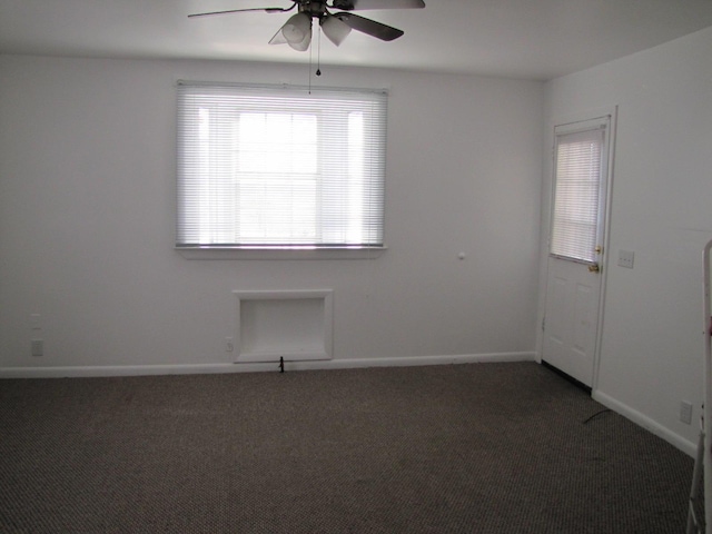 carpeted spare room with baseboards and a ceiling fan