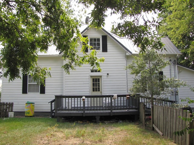 back of house with a yard, fence, metal roof, and a wooden deck