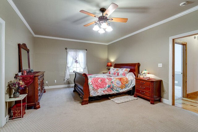 carpeted bedroom featuring ornamental molding, baseboards, and ceiling fan