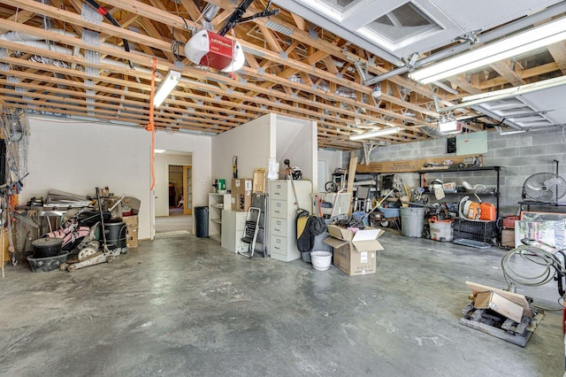 garage with a garage door opener and concrete block wall