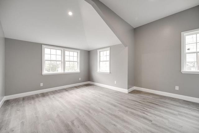 unfurnished room with light hardwood / wood-style flooring and vaulted ceiling