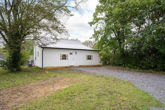 back of house featuring central AC unit and a yard