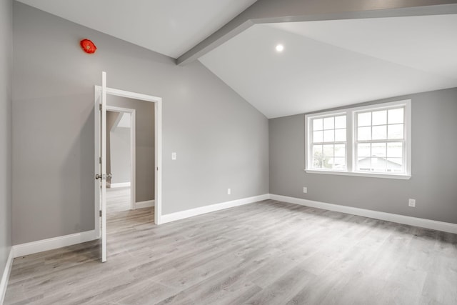 bonus room with lofted ceiling with beams and light wood-type flooring