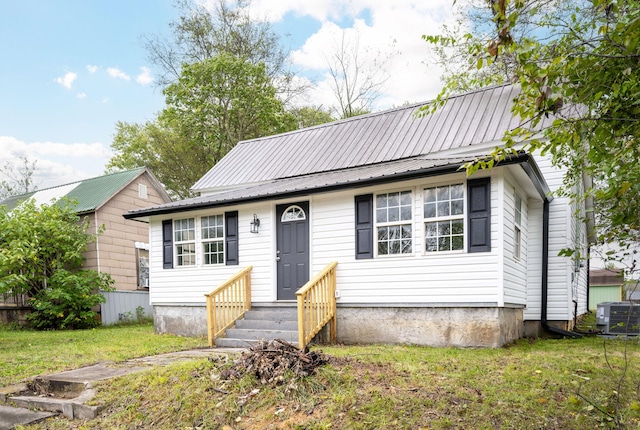 view of front of home with central air condition unit and a front lawn