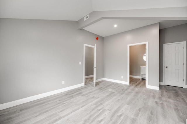 unfurnished bedroom with vaulted ceiling and light hardwood / wood-style flooring