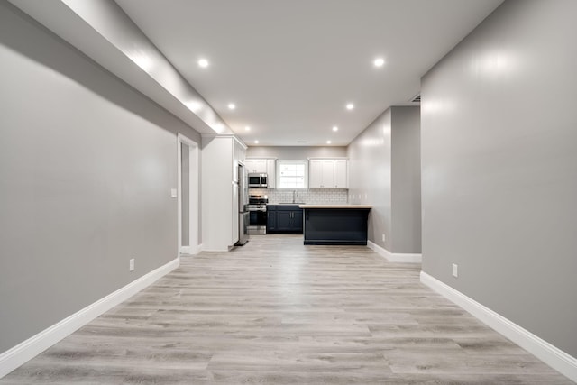 kitchen featuring white cabinets, sink, light wood-type flooring, and stainless steel appliances