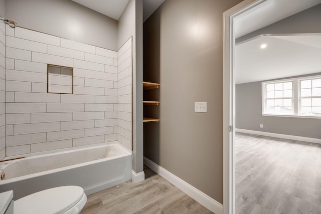 bathroom featuring tiled shower / bath, wood-type flooring, and toilet