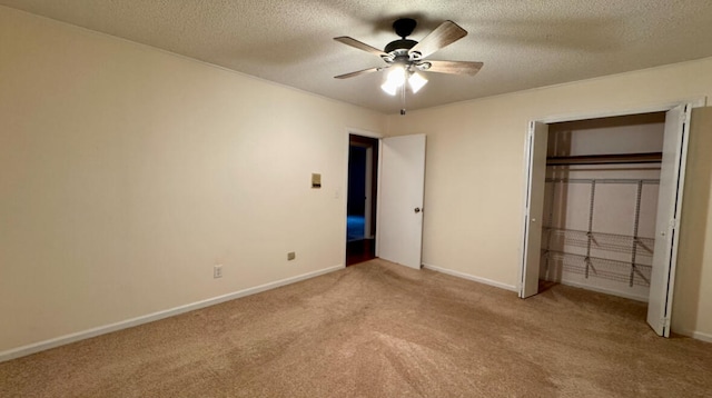 unfurnished bedroom with light carpet, a textured ceiling, a closet, and ceiling fan