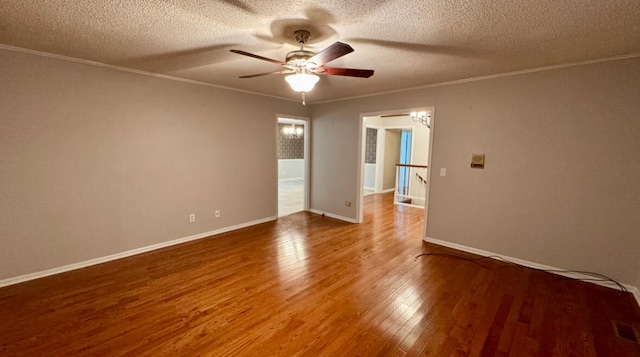 spare room featuring wood-type flooring, a textured ceiling, ceiling fan, and ornamental molding