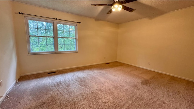 carpeted empty room featuring ceiling fan and a textured ceiling