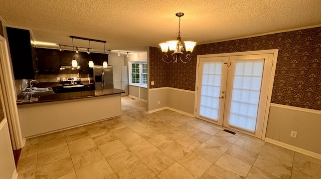 kitchen featuring an inviting chandelier, sink, hanging light fixtures, kitchen peninsula, and stainless steel appliances