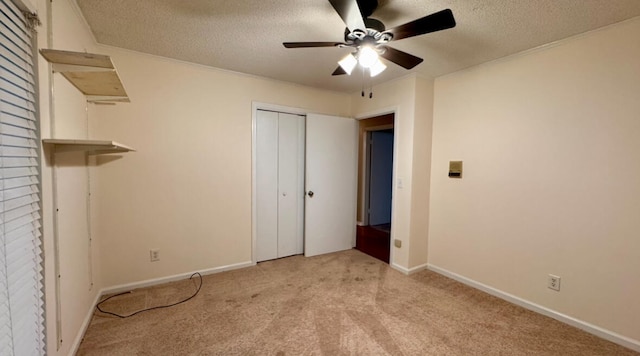 unfurnished bedroom featuring ceiling fan, a textured ceiling, light carpet, and a closet