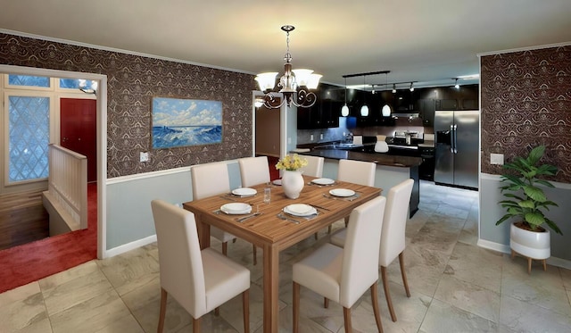 dining space with ornamental molding and a notable chandelier