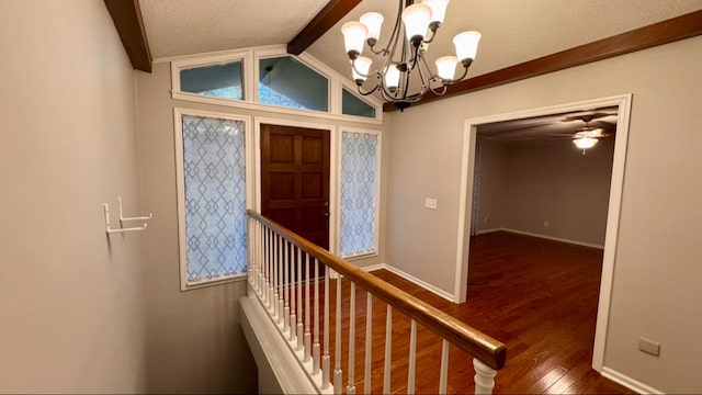 foyer entrance with vaulted ceiling with beams, dark hardwood / wood-style floors, a textured ceiling, and ceiling fan with notable chandelier