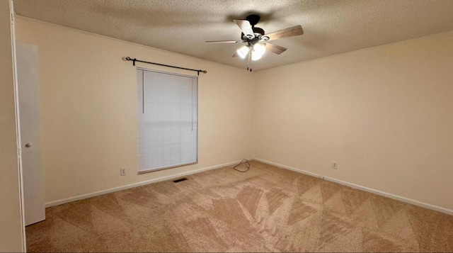 empty room with a textured ceiling, ceiling fan, and light carpet