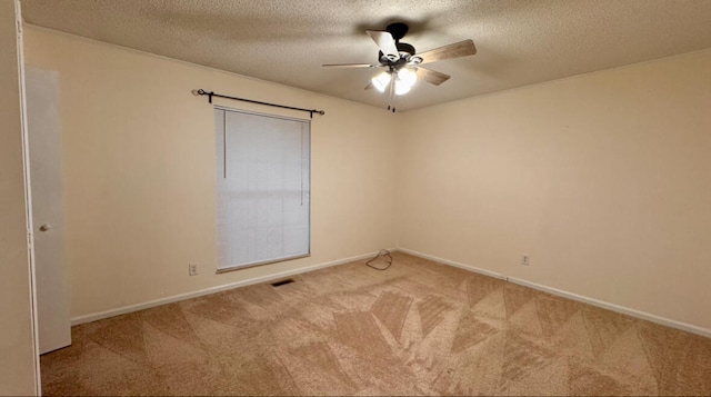 unfurnished room with a textured ceiling, light colored carpet, and ceiling fan