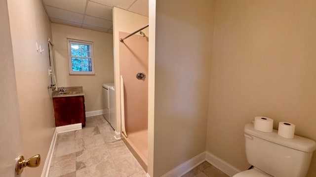 bathroom featuring a shower, vanity, a paneled ceiling, and washer and dryer