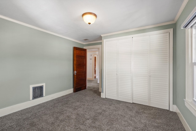 unfurnished bedroom featuring carpet floors, crown molding, and a closet