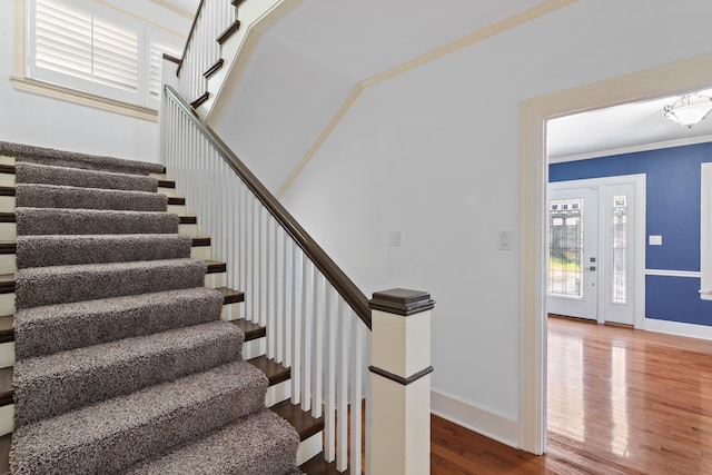 stairs with crown molding and hardwood / wood-style floors