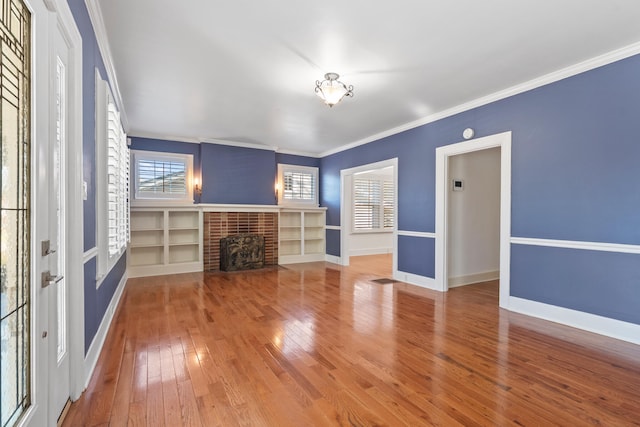 unfurnished living room with a fireplace, crown molding, and hardwood / wood-style floors