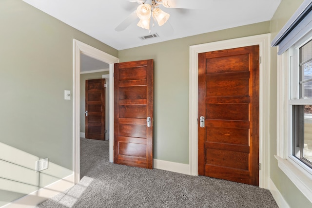 interior space with carpet flooring and ceiling fan