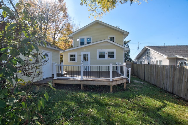 back of property with a yard and a deck