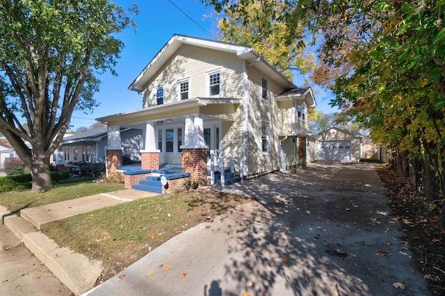 view of front of property featuring a porch, a garage, and an outbuilding