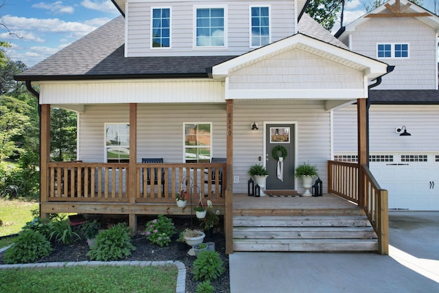view of front of property featuring covered porch, roof with shingles, a garage, and driveway