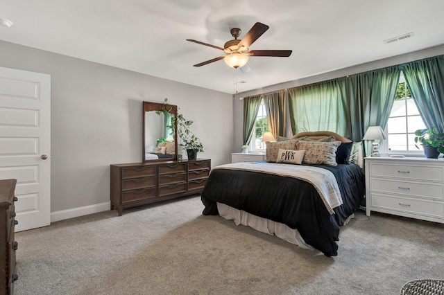 bedroom with multiple windows, carpet flooring, a ceiling fan, and baseboards