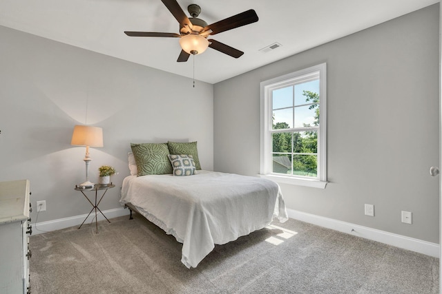 bedroom featuring baseboards, light colored carpet, and a ceiling fan