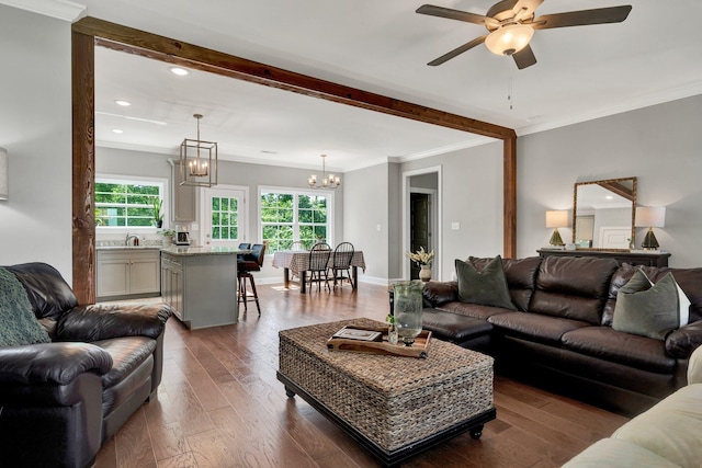 living area featuring a chandelier, a ceiling fan, dark wood finished floors, recessed lighting, and crown molding