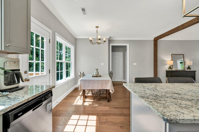 dining area with a chandelier, crown molding, wood finished floors, and baseboards
