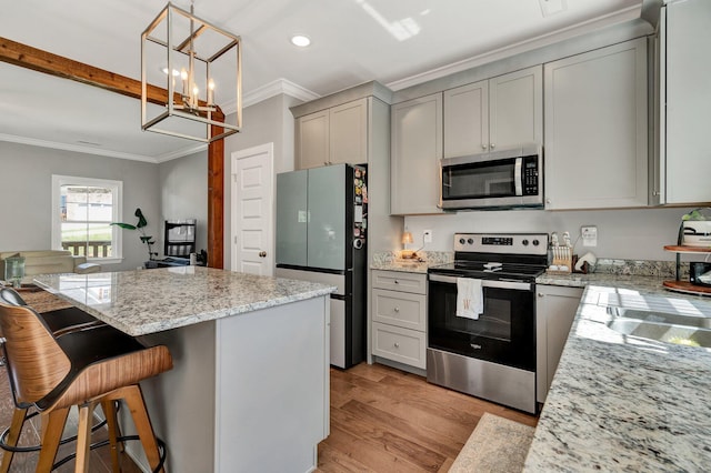 kitchen with appliances with stainless steel finishes, gray cabinets, crown molding, a chandelier, and light wood-style flooring