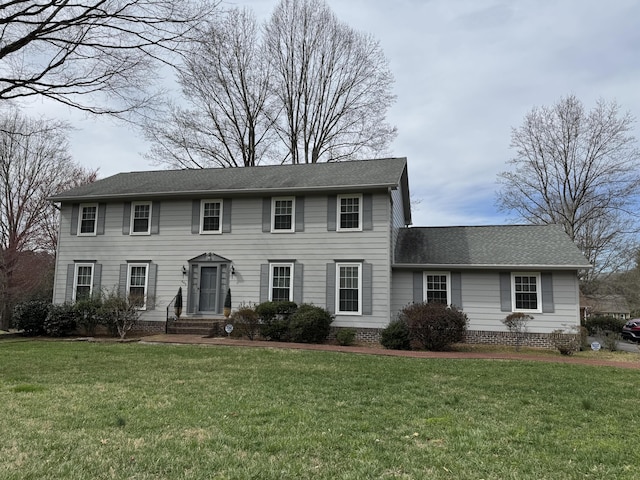 colonial-style house with roof with shingles and a front yard