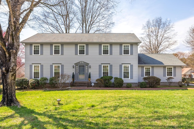 colonial inspired home featuring a front lawn and roof with shingles