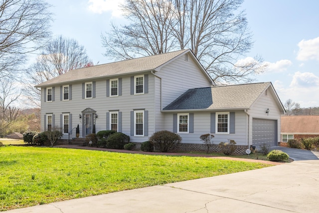 colonial home featuring a garage, roof with shingles, concrete driveway, and a front yard