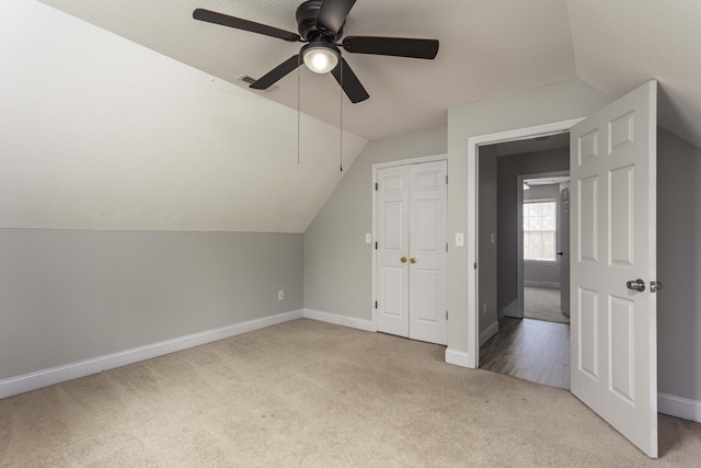 bonus room featuring lofted ceiling, carpet flooring, and baseboards