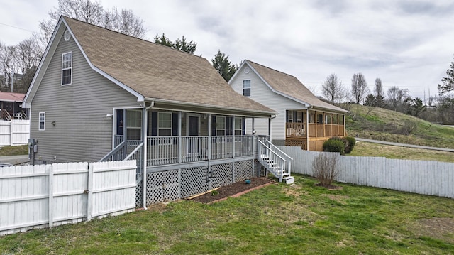 back of house with fence, a porch, a yard, a shingled roof, and stairs