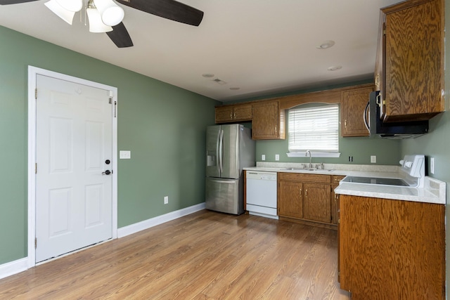 kitchen with stainless steel fridge with ice dispenser, light countertops, white dishwasher, stove, and a sink